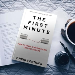 A copy of The First Minute on a table with notepad and coffee helping the reader write better