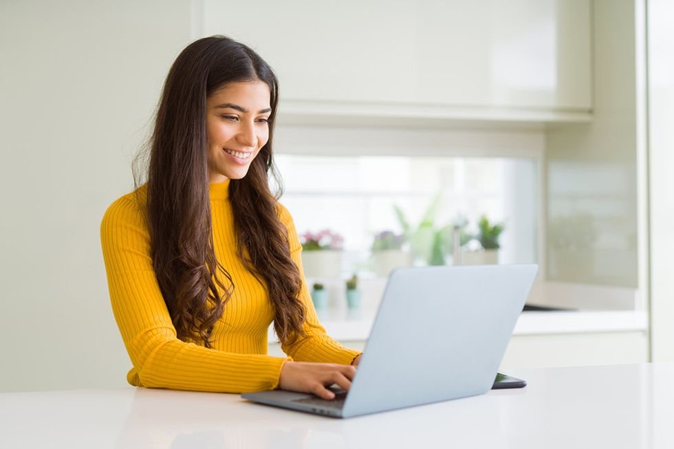 Woman on laptop writes and formats her resume to get it past the ATS